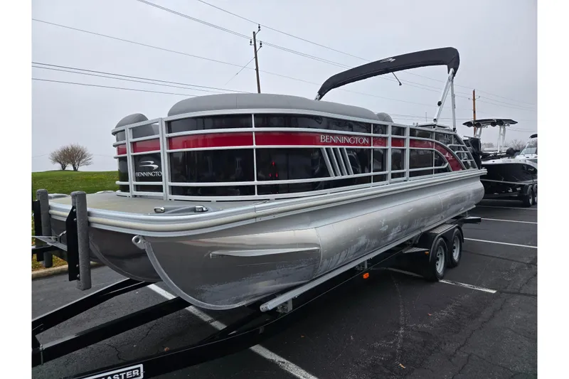 Slide: The Image of 2022 Bennington LX 24 Swingback pontoon boat on trailer in parking lot. - 5