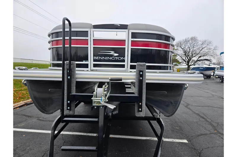 Slide: The Image of 2022 Bennington LX 24 Swingback pontoon boat on trailer in parking lot. - 6