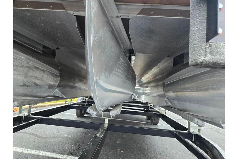 Slide: The Image of Underneath view of a 2022 Bennington LX 24 Swingback pontoon boat on a trailer. - 7