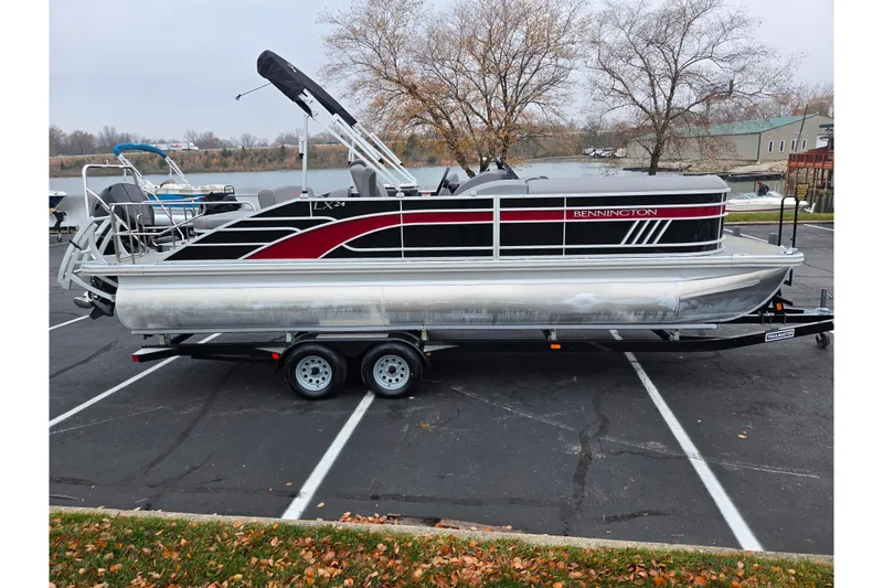 Slide: The Image of 2022 Bennington LX 24 Swingback pontoon boat on trailer in parking lot. - 9