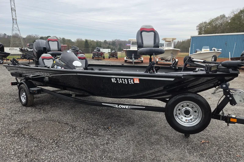 Slide: The Image of 2018 Lowe Stinger 195C fishing boat on trailer, parked outdoors. - 2