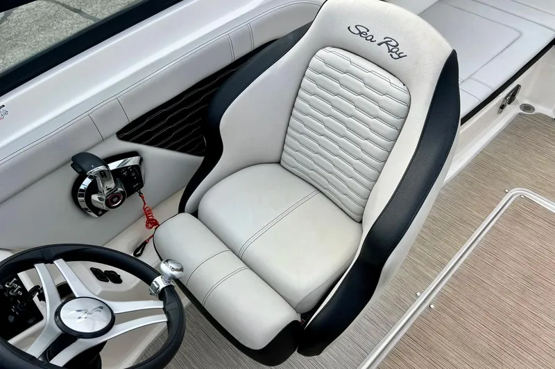 Slide: The Image of 2023 Searay SPX230 boat interior with steering wheel and captain's seat. - 39