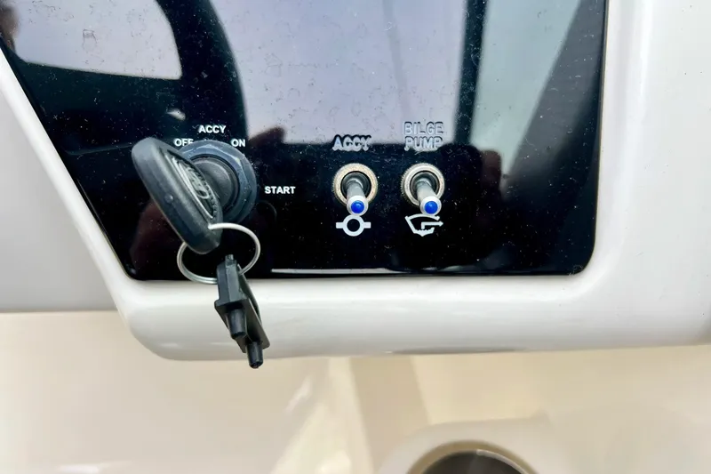 Slide: The Image of Control panel of 2023 Searay SPX230 boat with key ignition and switches. - 42
