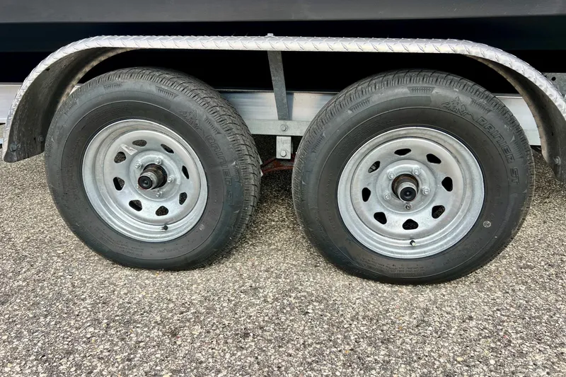 Slide: The Image of Trailer wheels for 2023 Searay SPX230 boat on asphalt surface. - 5
