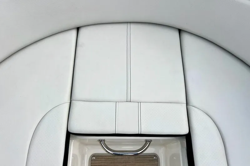 Slide: The Image of 2023 Searay SPX230 boat interior with white cushioned seating and stainless steel handle. - 53