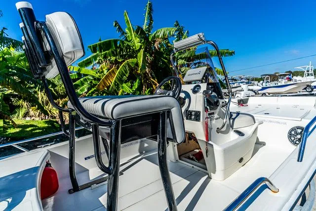Slide: The Image of Mako SKIFF 15CC 2022 boat with console and seating, surrounded by palm trees. - 6