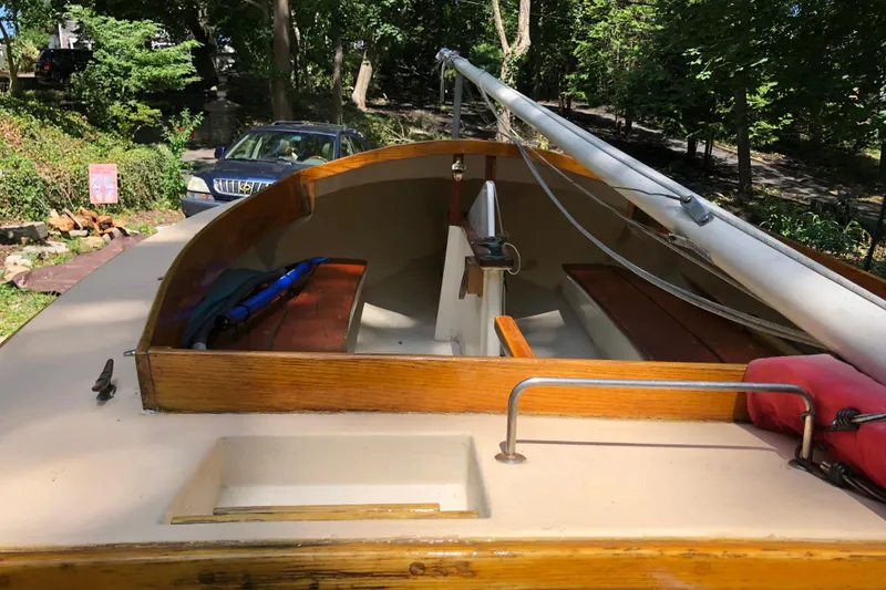 Slide: The Image of 1994 STUR DEE sailboat with wooden interior, parked outdoors near trees and a car. - 13