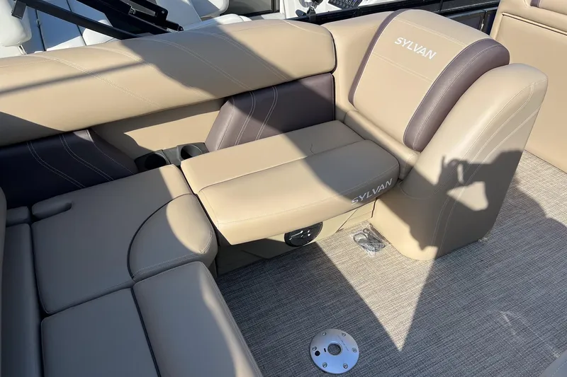 Slide: The Image of 2026 Sylvan Mirage 822 CLZ boat interior with beige and brown seating. - 10