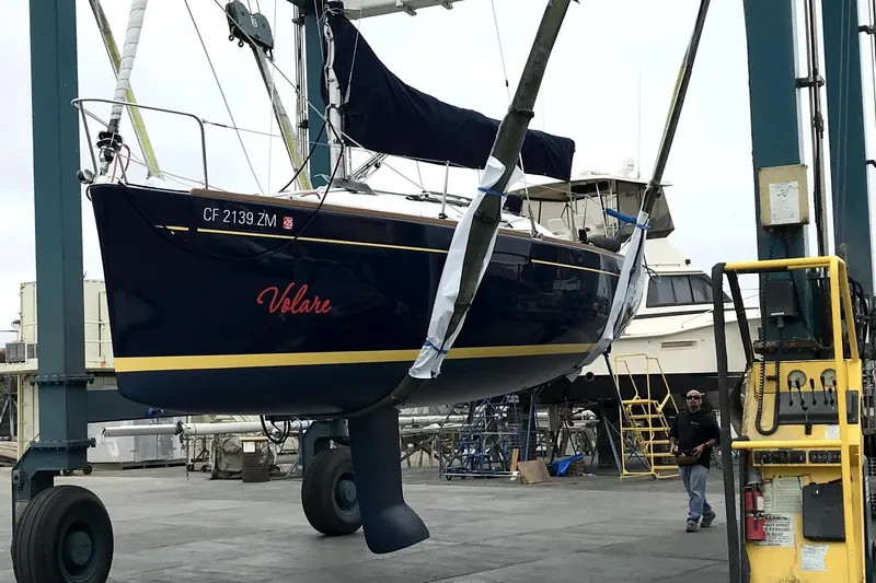 Slide: The Image of 2014 Beneteau FIRST 25 S sailboat named "Volare" being lifted at a marina. - 5