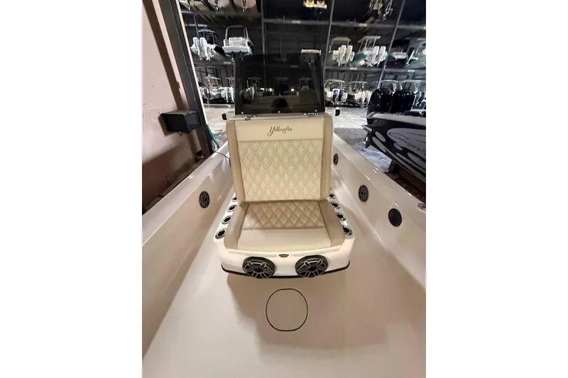 Slide: The Image of 2017 Yellowfin 24 Bay CE boat interior with cushioned seating and speakers. - 17