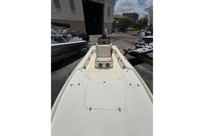 Slide: The Image of 2017 Yellowfin 24 Bay CE boat docked, showcasing spacious deck and seating area. - 8