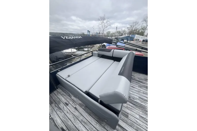 Slide: The Image of 2025 Veranda Relax VR 25 VLC pontoon boat with gray seating on a wooden deck. - 3