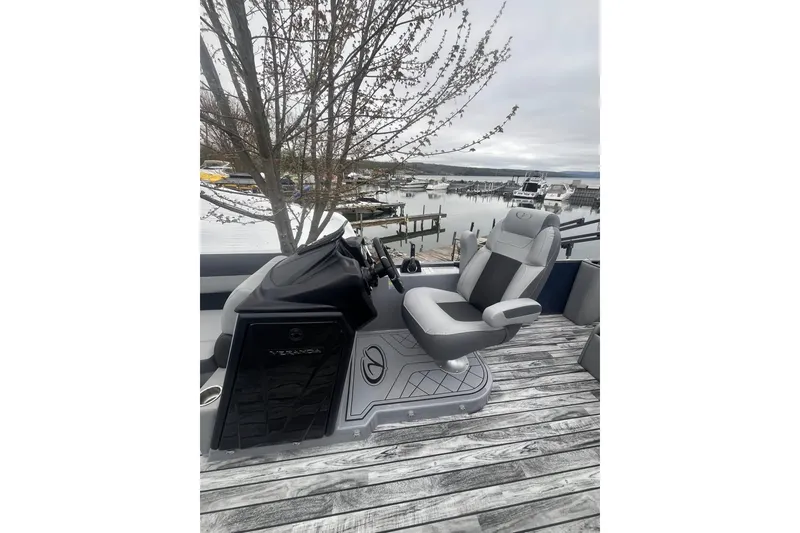 Slide: The Image of 2025 Veranda Relax VR 25 VLC boat interior with helm and seating by a marina. - 4
