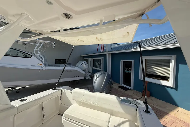 Slide: The Image of 2019 Edgewater 230CX Crossover boat at a marina with blue building backdrop. - 10