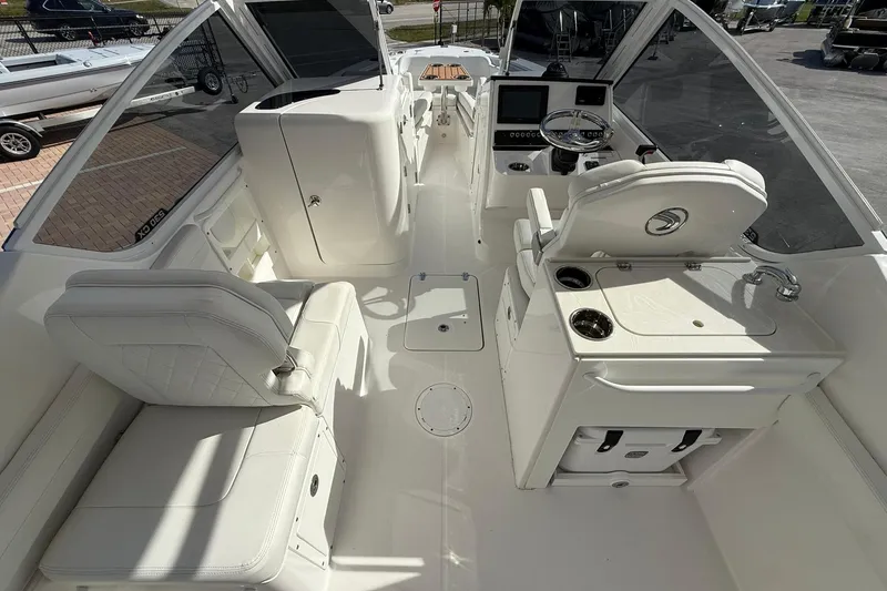Slide: The Image of 2019 Edgewater 230CX Crossover boat interior with seating, steering, and control panel. - 11