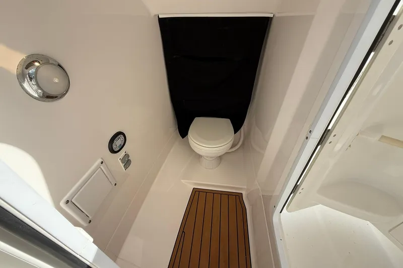 Slide: The Image of 2019 Edgewater 230CX Crossover boat interior with compact marine toilet. - 13