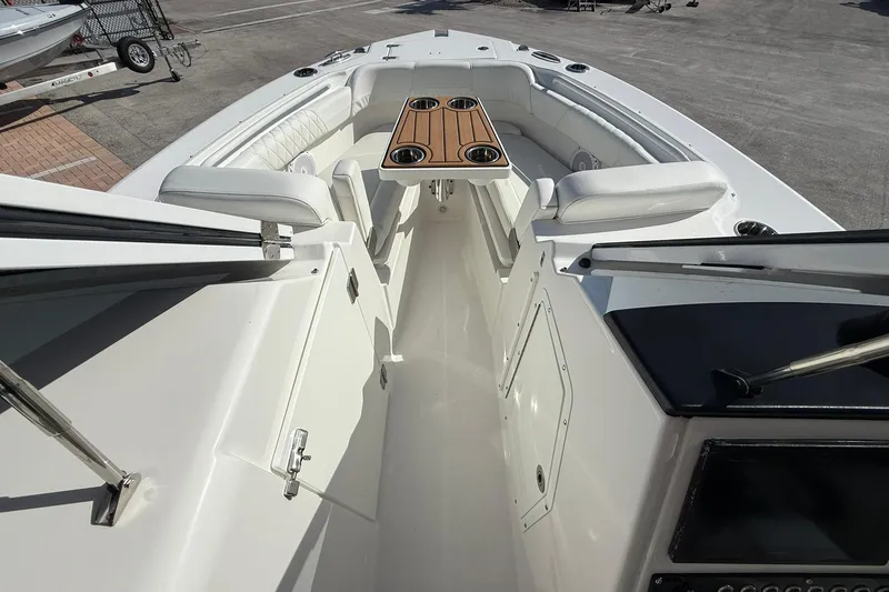 Slide: The Image of 2019 Edgewater 230CX Crossover boat interior with seating and wooden table. - 18