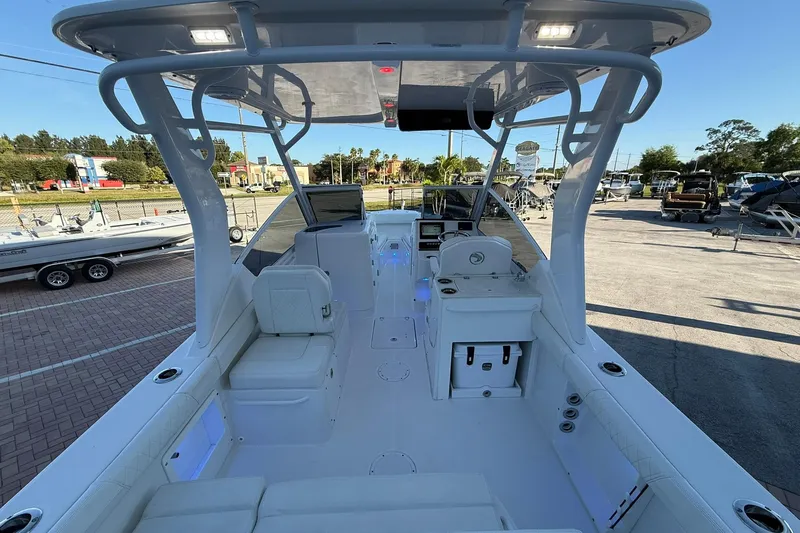 Slide: The Image of 2019 Edgewater 230CX Crossover boat interior with seating and control panel in a marina setting. - 7