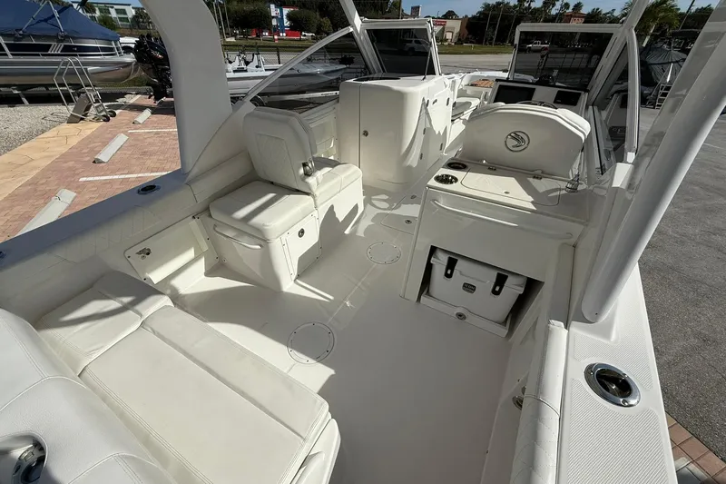 Slide: The Image of 2019 Edgewater 230CX Crossover boat interior with white seating and storage compartments. - 8