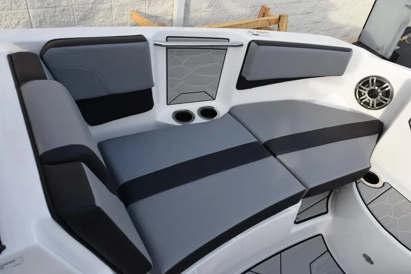 Slide: The Image of 2026 Yamaha Boats 222XD interior seating with gray and black upholstery, cup holders, and speaker. - 14