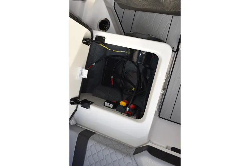 Slide: The Image of Open storage compartment in 2026 Yamaha Boats 222XD, showing wiring and components. - 17