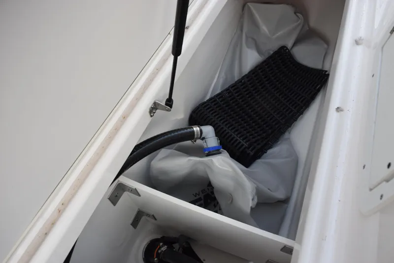 Slide: The Image of Storage compartment of 2026 Yamaha Boats 222XD with hose and mat. - 20