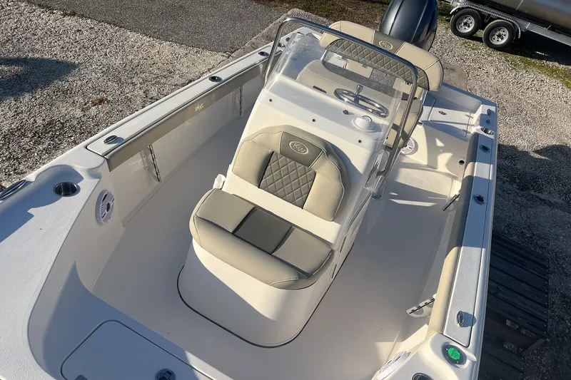 Slide: The Image of 2026 Key West 188 Bay Reef boat interior with beige seating and steering console. - 16