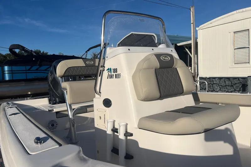 Slide: The Image of 2026 Key West 188 Bay Reef boat with beige seating and console, docked outdoors. - 3
