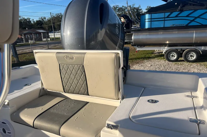 Slide: The Image of 2026 Key West 188 Bay Reef boat interior with cushioned seating and motor. - 9