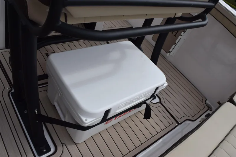 Slide: The Image of 2026 Yamaha Boats 255 FSH Sport H deck with cooler and seating area. - 11