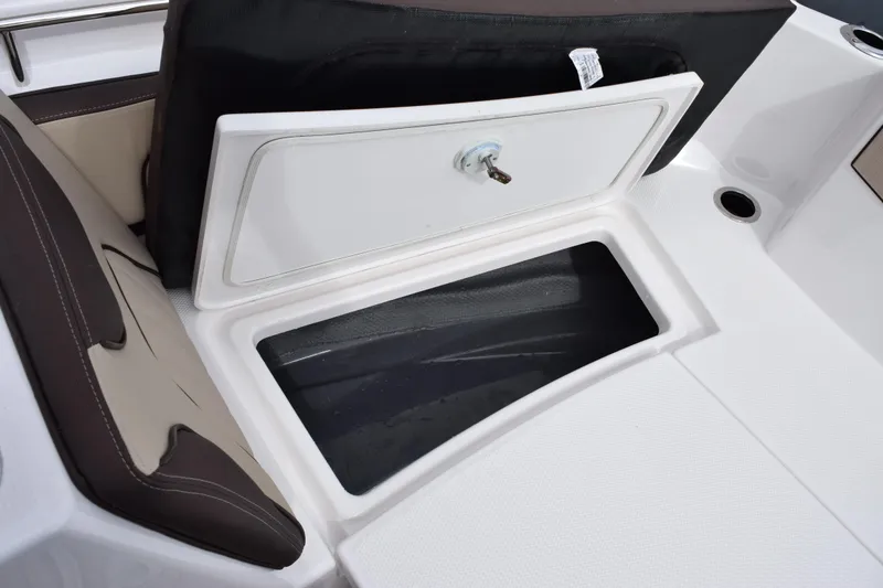 Slide: The Image of 2026 Yamaha Boats 255 FSH Sport H storage compartment with open hatch and seating area. - 16