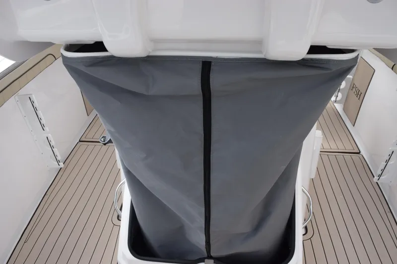 Slide: The Image of 2026 Yamaha Boats 255 FSH Sport H interior with gray storage compartment and sleek deck design. - 17
