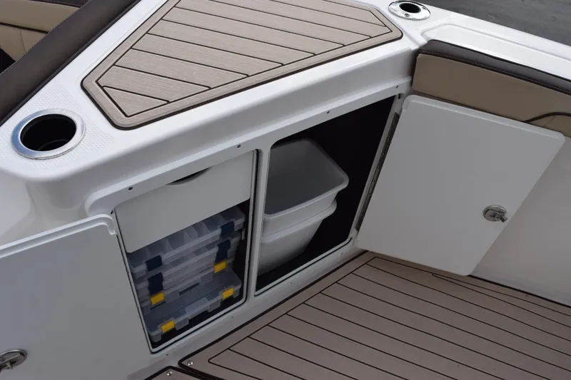 Slide: The Image of 2026 Yamaha Boats 255 FSH Sport H storage compartment with tackle boxes and bin. - 18