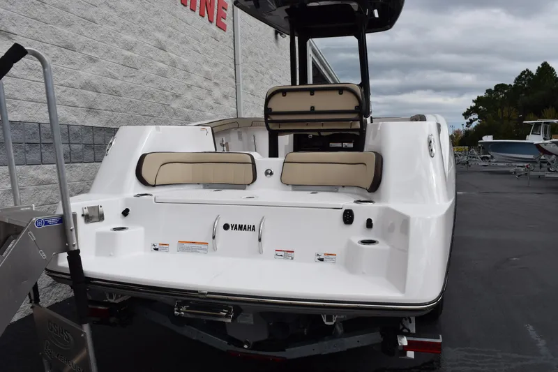 Slide: The Image of 2026 Yamaha Boats 255 FSH Sport H, rear view, white exterior, parked outdoors. - 5