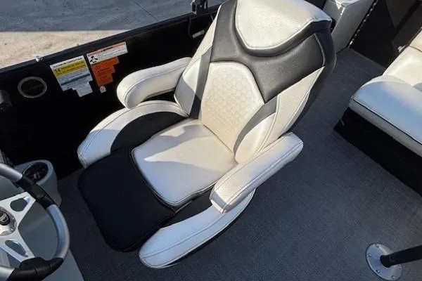 Slide: The Image of Captain's chair on 2016 Southbay 523CR Super Sport Tri-Toon boat, featuring black and white upholstery. - 20