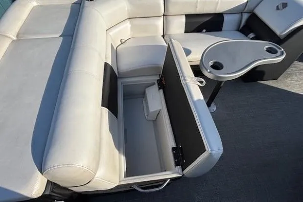 Slide: The Image of 2016 Southbay 523CR Super Sport Tri-Toon interior with open storage compartment and cupholder table. - 24