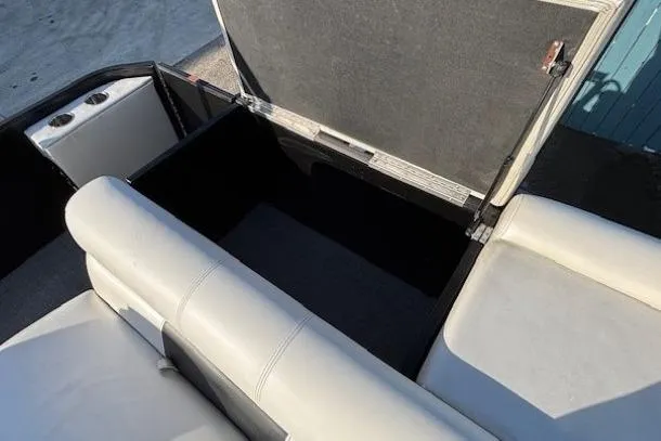 Slide: The Image of 2016 Southbay 523CR Super Sport Tri-Toon boat with open storage compartment and white seating. - 29
