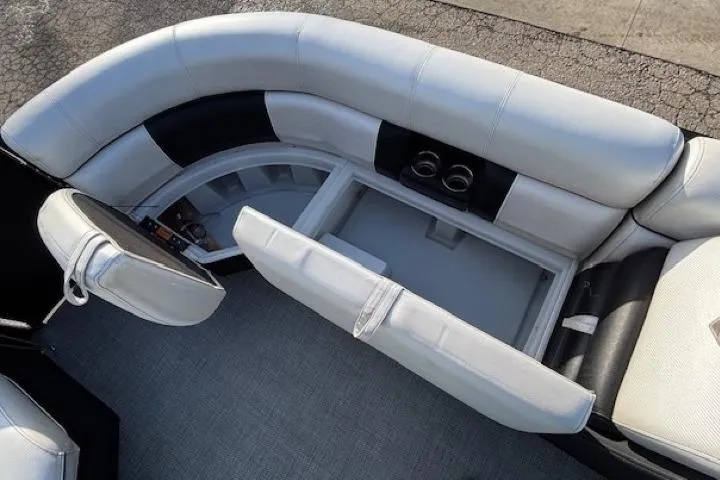 Slide: The Image of 2016 Southbay 523CR Super Sport Tri-Toon interior with white seating and storage compartment. - 9