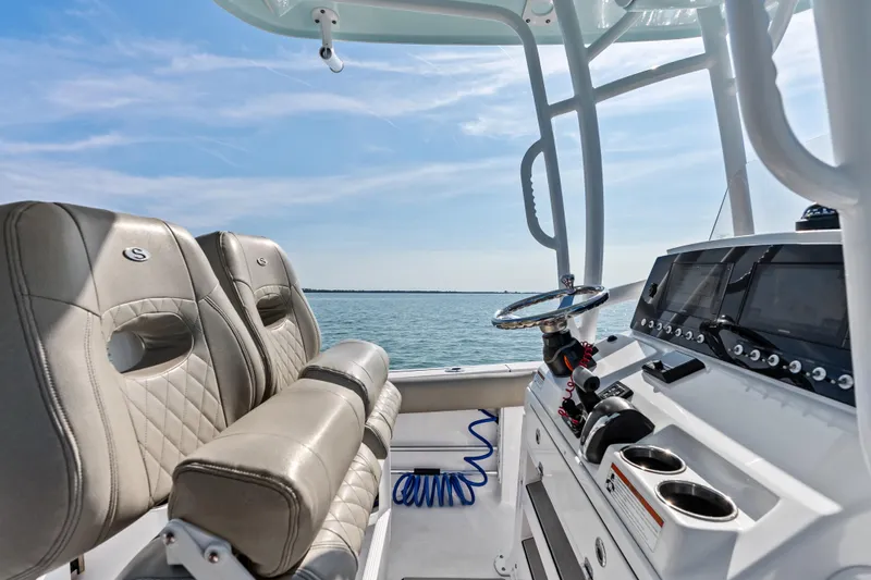 Slide: The Image of 2021 Sportsman Open 212 Center Console boat interior with steering wheel and seating, ocean view. - 13