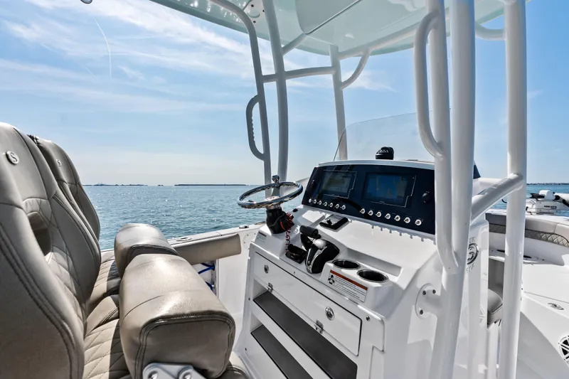 Slide: The Image of 2021 Sportsman Open 212 Center Console boat interior with steering wheel and navigation system. - 14