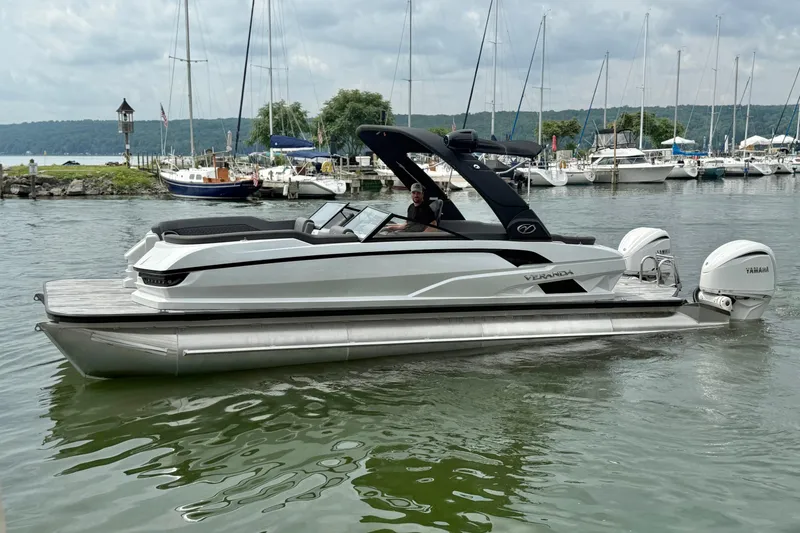 The Image of 2025 Veranda V One Twin Engine boat docked in a marina with scenic background. - 0