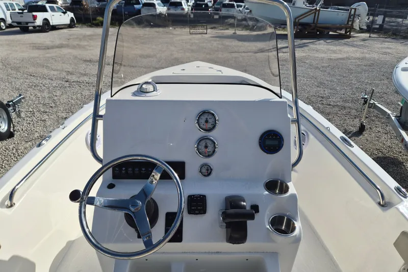 Slide: The Image of 2026 Key West 189 FS boat dashboard with steering wheel and gauges in a parking lot. - 12