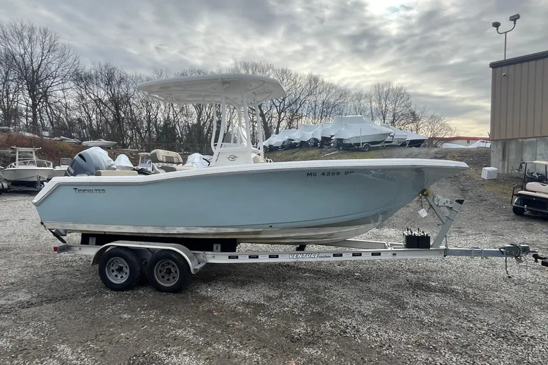 The Image of 2021 22 Tidewater Adventure boat on trailer, parked outdoors under cloudy sky. - 0