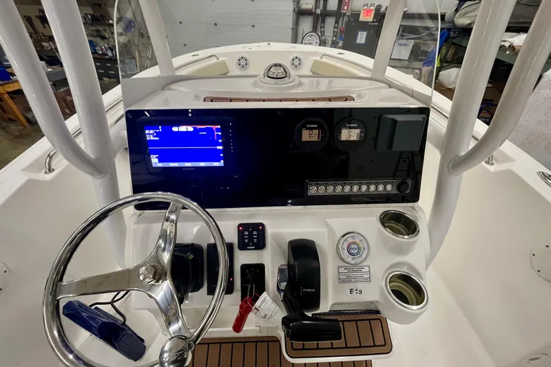 Slide: The Image of 2021 22 Tidewater Adventure boat dashboard with steering wheel and navigation display. - 13