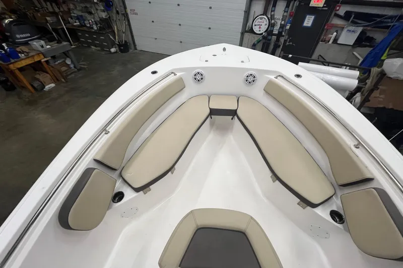 Slide: The Image of 2021 22 Tidewater Adventure boat interior with beige seating in a garage setting. - 22