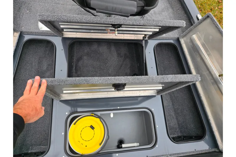 Slide: The Image of 2022 Tracker Pro Team 175 TF boat storage compartments with open lids and visible interior. - 16