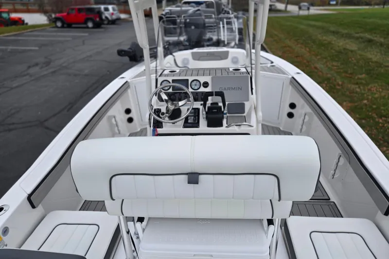Slide: The Image of 2022 Yamaha Boats 210 FSH Sport interior with steering console and seating. - 11