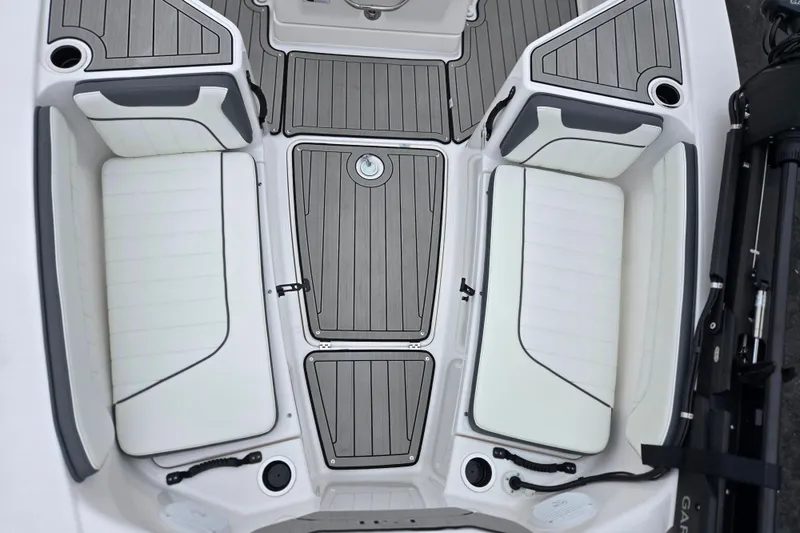 Slide: The Image of 2022 Yamaha Boats 210 FSH Sport interior with cushioned seating and sleek deck design. - 22