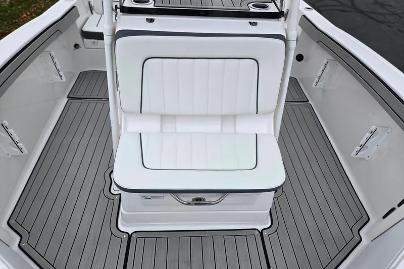 Slide: The Image of 2022 Yamaha Boats 210 FSH Sport interior with white seating and gray flooring. - 24