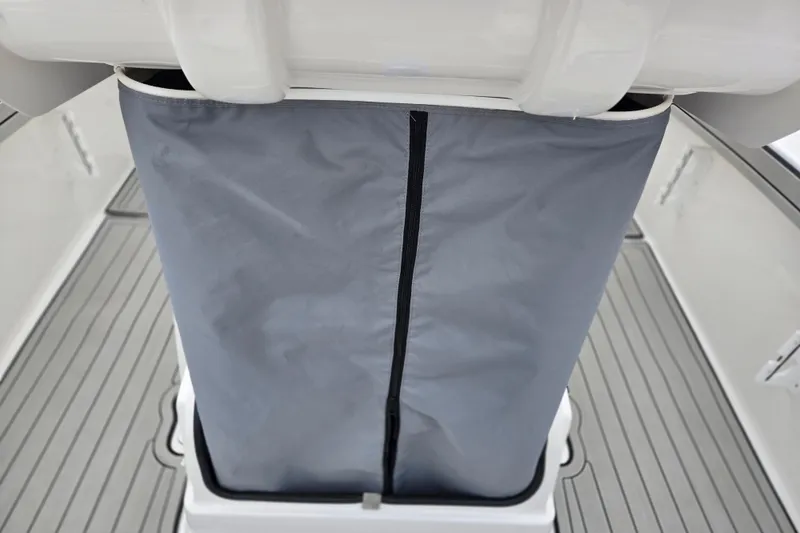 Slide: The Image of 2022 Yamaha Boats 210 FSH Sport interior with gray storage cover. - 25